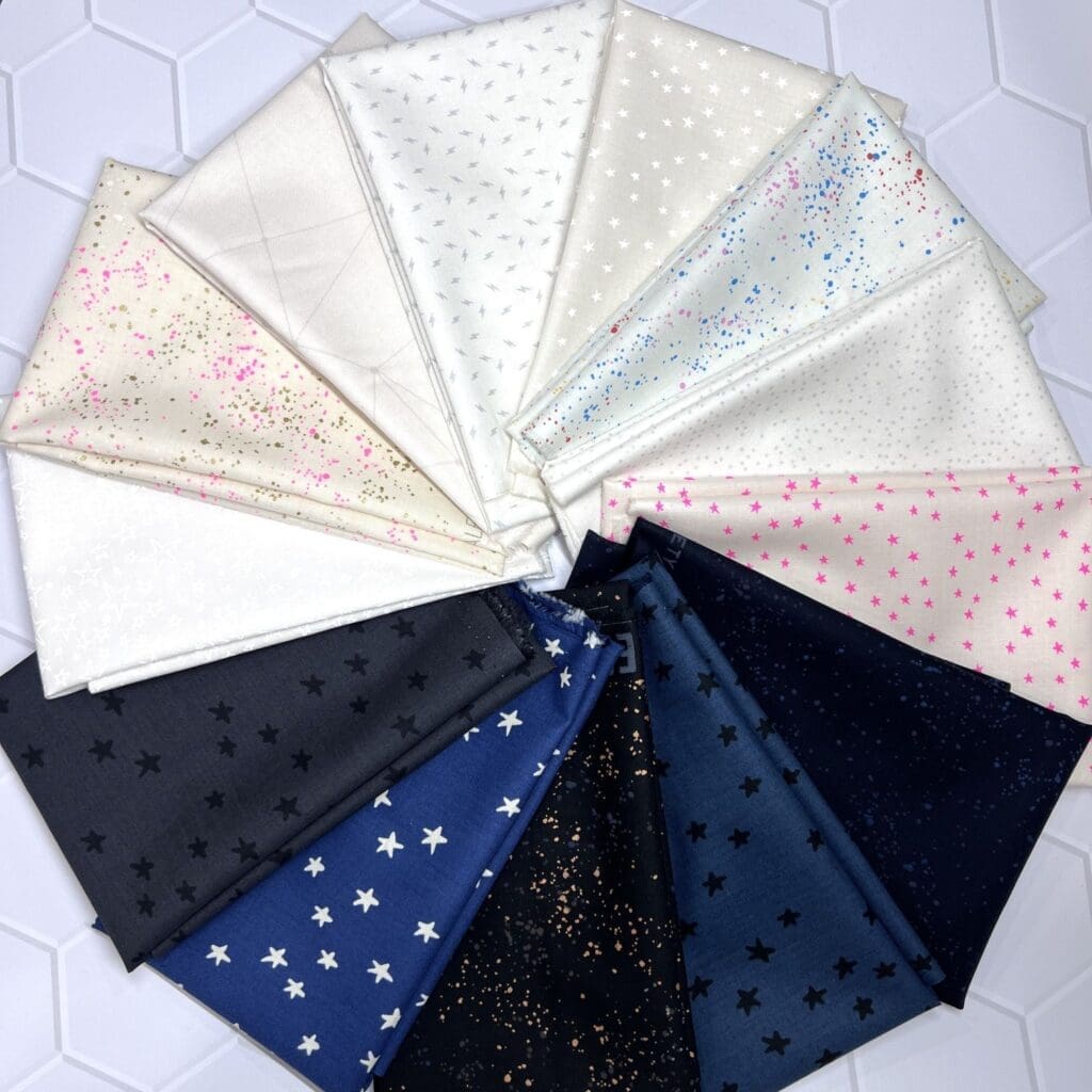 A geometric quilt with star-shaped blue, green, and white patterns.